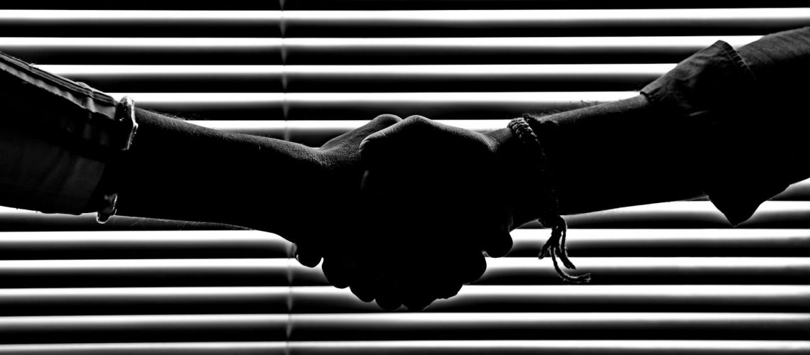 monochrome photography of people shaking hands